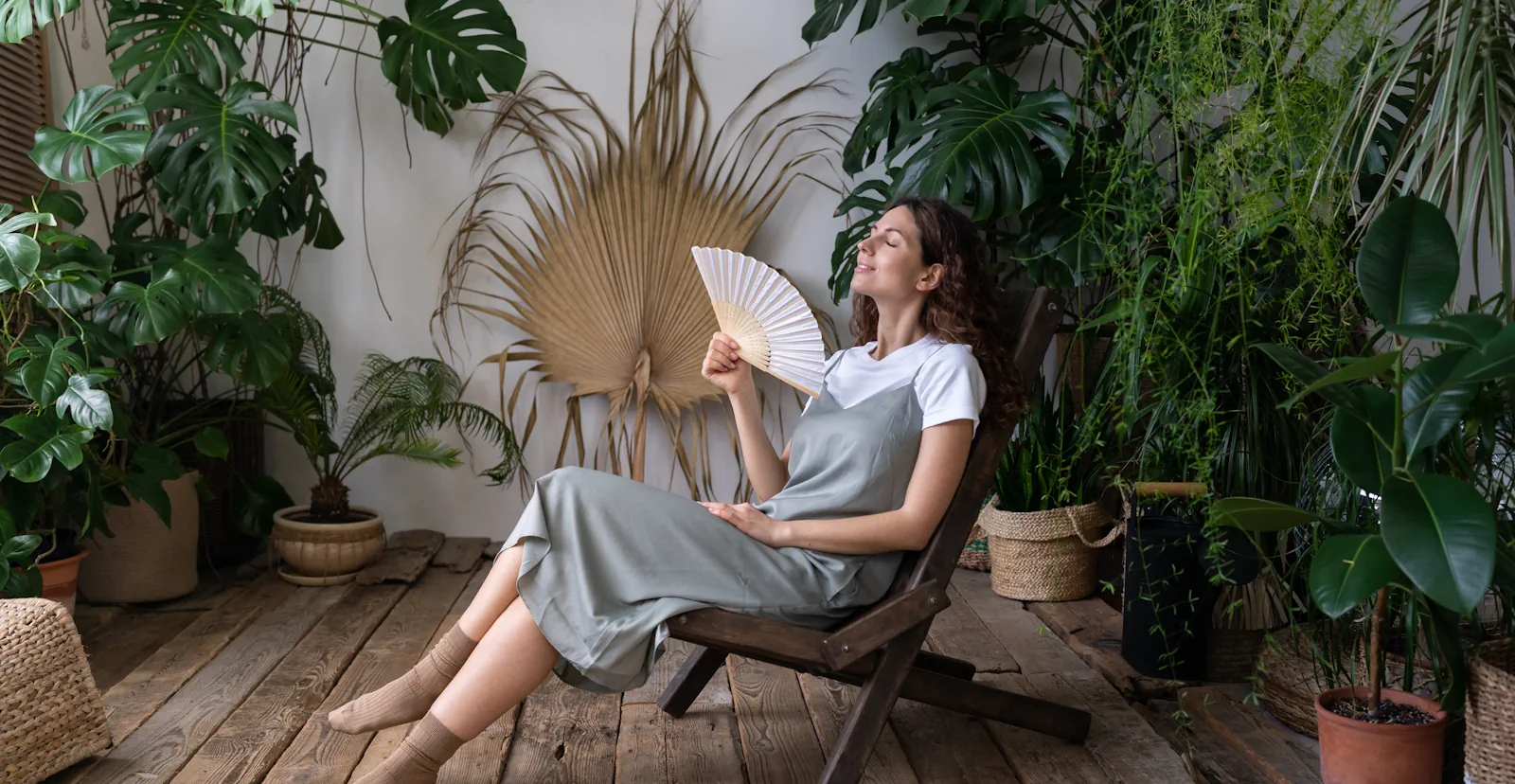 happy-woman-florist-refreshing-home-garden-breathing-fresh-air-hold-paper-fan-hand-hot-day